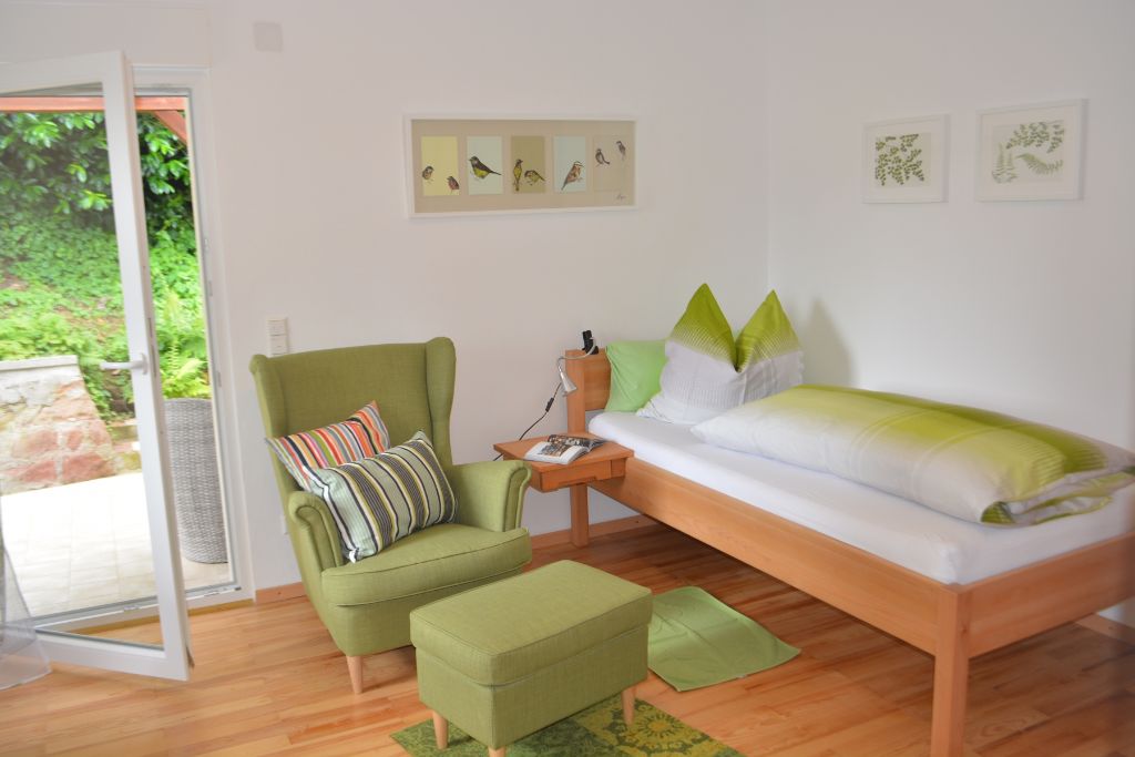 Apartment mit Terrasse und grünem Sessel